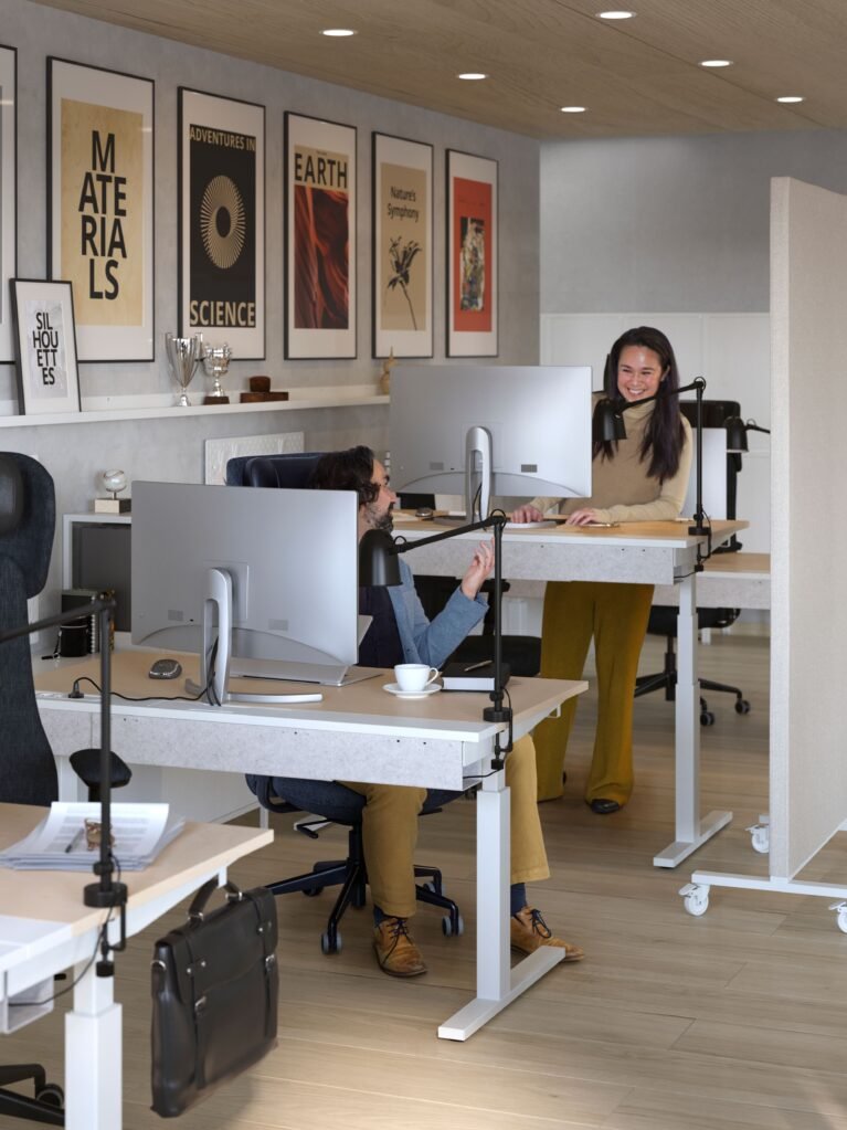 IKEA MITTZON electric sit/stand desks at seated and standing heights, with white frames and wood-effect tops; monitors, chairs and accessories sold separately